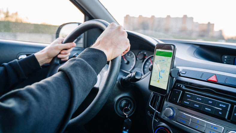 Uber rideshare driver using a mounted navigation app while behind the wheel.